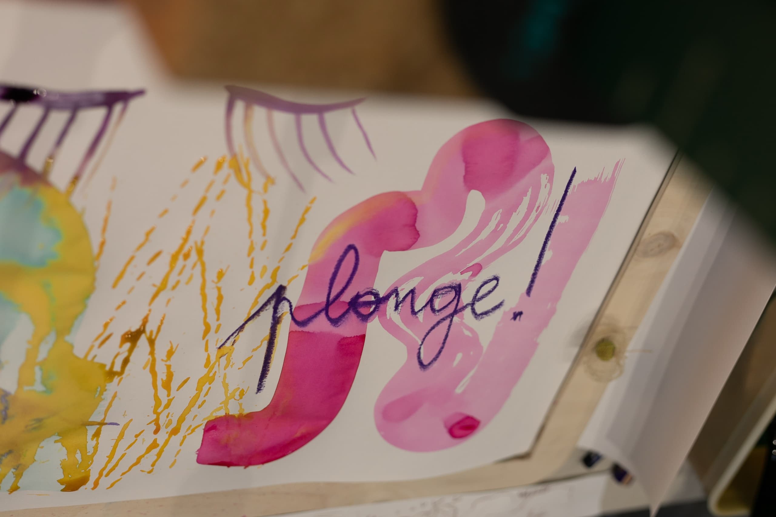 Carnet ouvert sur une page aquarellée où est écrit « plonge ! »