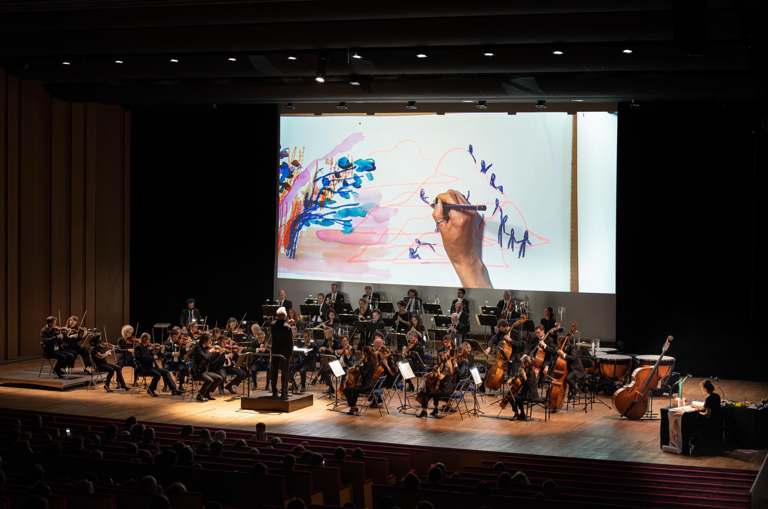 Dessin en direct projeté au-dessus d’un orchestre en concert